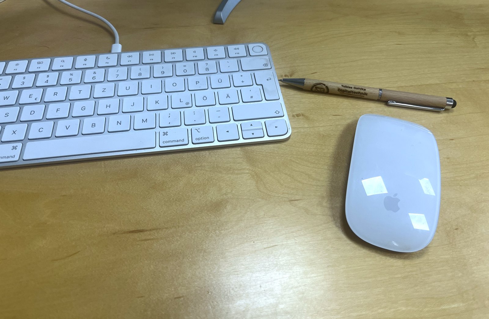 Arbeitsplatz von Tobias Gohlke - Digitaltechnik: Tastatur, Maus und gravierter Marken-Stift